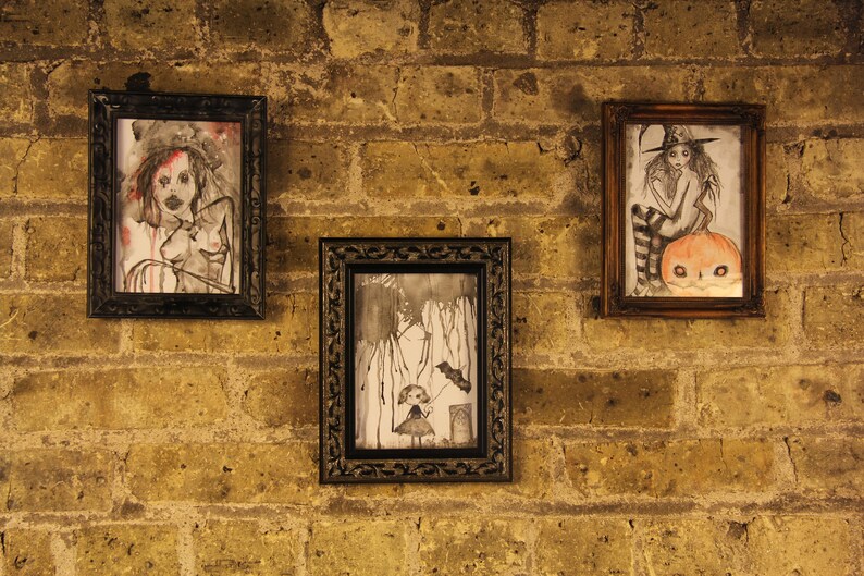 May include: Three framed drawings on a brick wall. The drawings are in black and white and feature a woman with long hair, a girl with a pumpkin, and a girl with a bird.