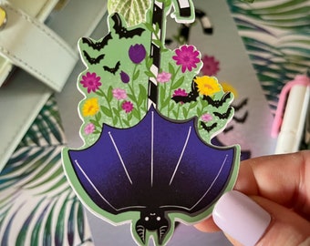 May include: A purple bat with a black and white striped candy cane hanging from its wings. The bat is surrounded by green leaves, flowers, and smaller bats.