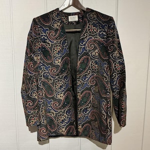 Può includere: Un blazer vintage con motivo paisley nero, rosso, blu, verde e oro. Il blazer ha uno scollo a V e maniche lunghe. L'etichetta recita "KORET".