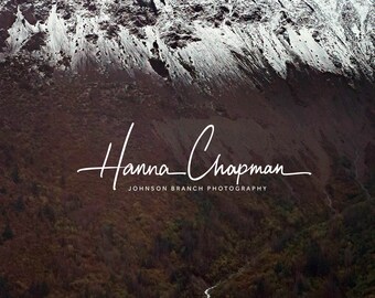 May include: A snowy mountain range with a small stream running down the side. The mountain is in the background and the stream is in the foreground. The water is a deep blue color. The text "Hanna Chapman" and "Johnson Branch Photography" is at the bottom of the image.