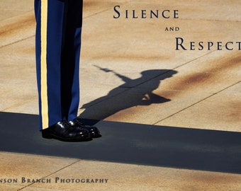 May include: A person in a blue uniform with a yellow stripe stands at attention with their shadow cast on the ground. The text "Silence and Respect" is written on the ground.