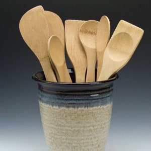 May include: A ceramic utensil holder with a blue and white glaze, filled with wooden spoons and spatulas.