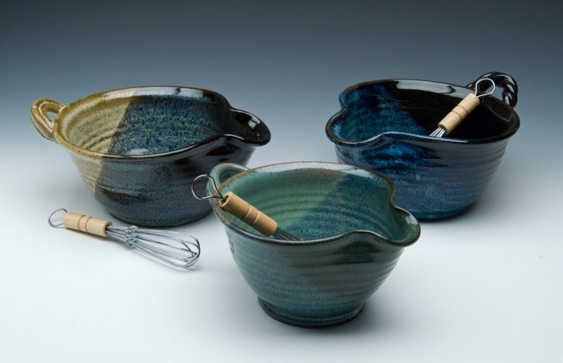 May include: Three ceramic mixing bowls with a blue and green glaze. Each bowl has a unique shape and a pouring spout. Two of the bowls have a wooden whisk inside.