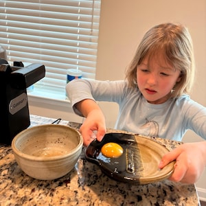 May include: A rustic wooden sign with the text "Welcome to our home" in white lettering. The sign features a distressed finish and a simple, inviting design, perfect for front door decor.