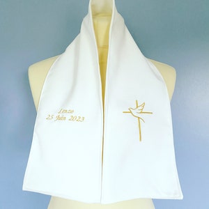 May include: White christening scarf with gold embroidery of a dove and cross. The scarf is personalized with the name "Lenzo" and the date "25 Juin 2023".