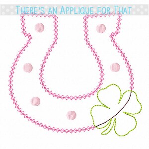 May include: Embroidered baby bib with a pink stitched outline and polka dots. A green and brown four-leaf clover is on the lower right. The text "THERE'S AN APPLIQUE FOR THAT" is at the top.