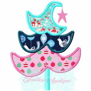 May include: A whimsical Christmas tree design with three layered sections. The top section is light blue with a reindeer pattern, the middle is navy with white birds, and the bottom is pink with ornaments. A pink star hangs from the top.