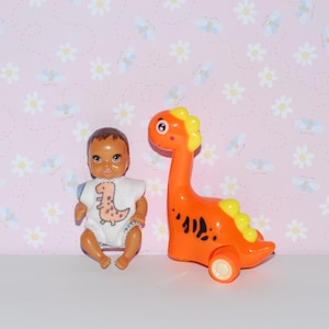 Handmade romper clothing and pull-back racing dinosaur toy for 3 inch plastic baby.  Baby doll is sold separately.