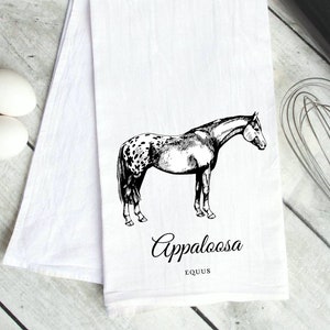 May include: A white kitchen towel with a black and white illustration of an Appaloosa horse. The text "Appaloosa" and "Equus" is printed below the horse.
