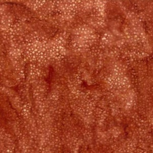 May include: A close-up of a rust-colored fabric with a white speckled pattern. The fabric has a subtle marbled effect.