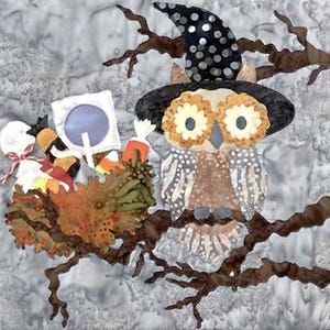 May include: A whimsical fabric art piece featuring an owl wearing a witch's hat, perched on a tree branch. The owl has large, flower-like eyes and is surrounded by colorful, stylized foliage and candy. The background is a mottled gray.