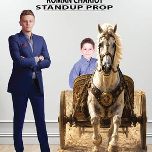 May include: A Roman chariot standup prop featuring a white horse pulling a brown chariot with gold accents. The prop displays a child sitting inside the chariot. The text ROMAN CHARIOT STANDUP PROP is printed at the top of the display.