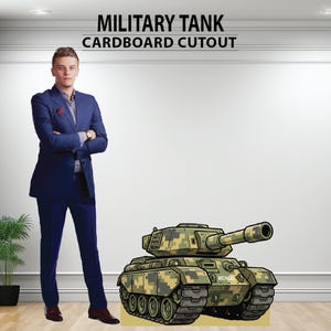May include: A cardboard cutout of a military tank with a camouflage pattern in shades of green, brown, and tan. The tank has a large gun barrel and the name "MICHAEL" is printed on the side. The text "MILITARY TANK CARDBOARD CUTOUT" is at the top.