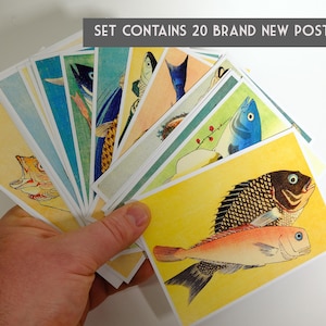 May include: A set of 20 brand new postcards featuring colorful illustrations of fish. The postcards are held in a hand, fanned out to show the different designs.  The text "SET CONTAINS 20 BRAND NEW POSTCARDS" is printed at the top of the image.