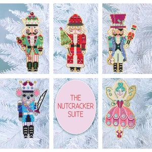 Puede incluir: Un conjunto de seis adornos navideños con personajes del ballet El Cascanueces. Los adornos están hechos de fieltro y bordados con detalles coloridos. El conjunto incluye un soldado Cascanueces, un Hada de Azúcar, un Rey Ratón, un árbol de Navidad, un Papá Noel y un príncipe Cascanueces.