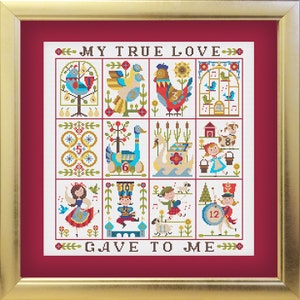 Puede incluir: Un diseño de punto de cruz enmarcado con un fondo rojo y cuadrados blancos y coloridos. El diseño presenta un estilo de arte popular tradicional con pájaros, animales y números. El texto "MY TRUE LOVE GAVE TO ME" está en la parte superior e inferior del diseño.