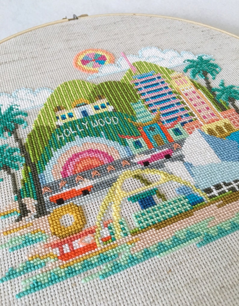 A cross stitch embroidery pattern of Los Angeles featuring famous landmarks and monuments.