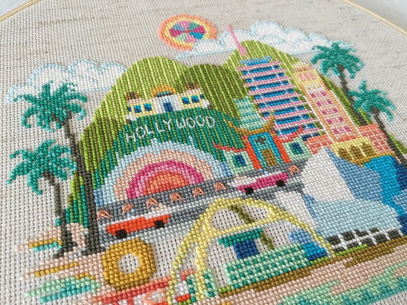 A cross stitch embroidery pattern of Los Angeles featuring famous landmarks and monuments.