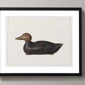 May include: A black and green wooden duck decoy with a brown head. The decoy is sitting on a white background.