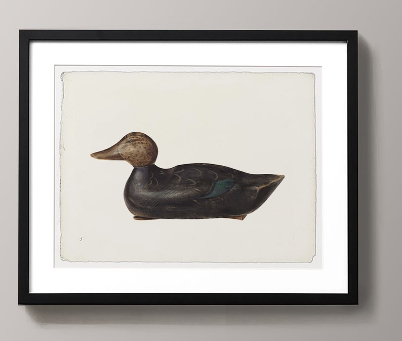 May include: A black and green wooden duck decoy with a brown head. The decoy is sitting on a white background.