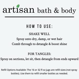 May include: White background with the text "artisan bath & body" in black. Instructions include "Shake well", "Spray onto dry, damp, or wet hair", and "Comb through to detangle & boost shine". Additional text details refill options.