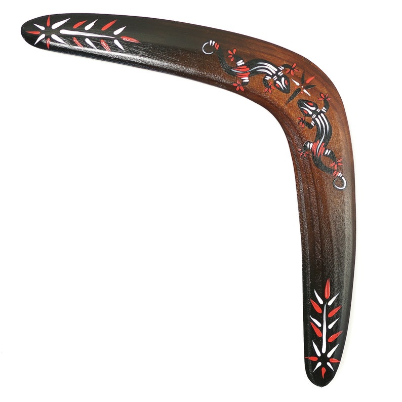 May include: A wooden boomerang with a black, red and white painted design featuring two lizards. The boomerang is curved and has a pointed tip.