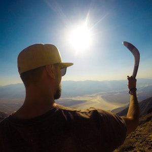 Man with a wooden boomerang in hand.