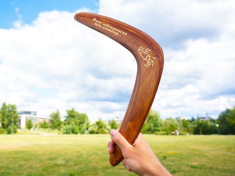 Personalized dark brown wooden boomerang in hand