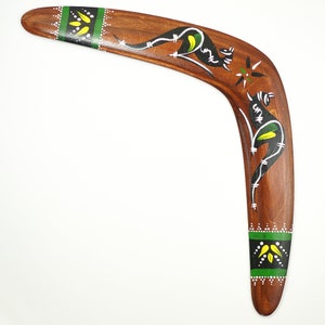 Op de afbeelding: Een houten boemerang met een gebogen vorm, met handgeschilderde kangoeroe-ontwerpen in zwart, wit en groen. De boemerang heeft een bruine afwerking met groene en witte accenten op de uiteinden. Een decoratief item.