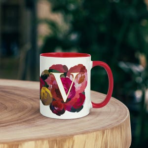 Taza personalizada con monograma floral carmesí (letra V) de cerámica colorida con asa roja. Regalo para amantes de las flores y el Día de la Madre.