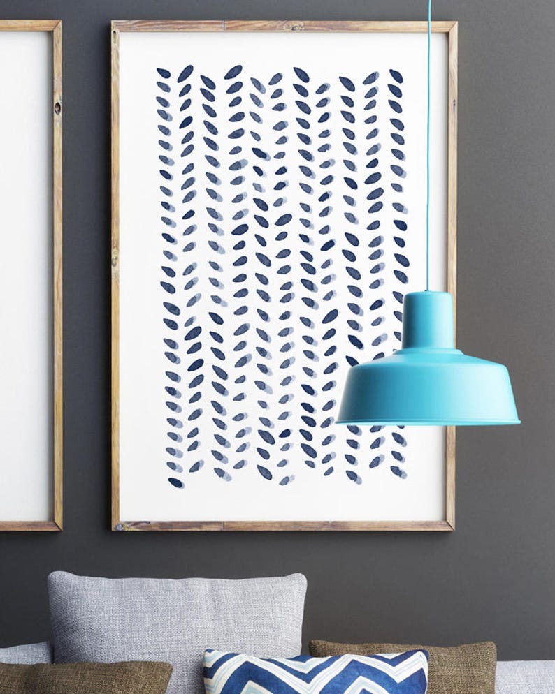 May include: A framed art print featuring a repeating pattern of blue leaf-like shapes on a white background. The artwork is in a wooden frame and hangs on a gray wall. A turquoise pendant light hangs in front of the artwork.