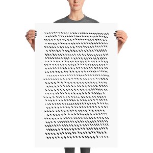 May include: A large, rectangular art print held by a person. The print features a pattern of small, black, diagonal dashes against a white background. The dashes are evenly spaced, creating a textured effect. The artwork is a minimalist, abstract design.