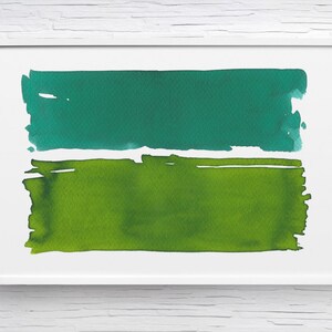 Op de afbeelding: Een ingelijste abstracte aquarel met twee horizontale kleurvlakken. Het bovenste vlak is een diepblauwgroen en het onderste vlak is levendig groen. Het kunstwerk wordt in een witte lijst gepresenteerd.
