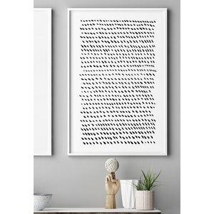 May include: A framed abstract art print featuring a pattern of black dashes on a white background. The artwork is displayed in a white frame. The image is part of a home decor theme.