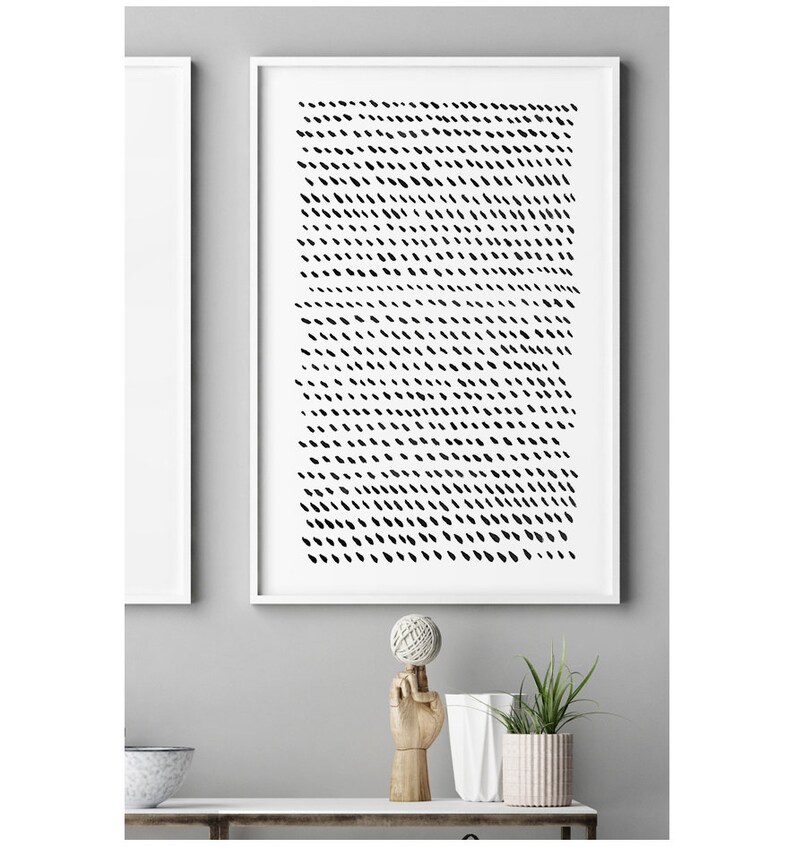 May include: A framed abstract art print featuring a pattern of black dashes on a white background. The artwork is displayed in a white frame. The image is part of a home decor theme.