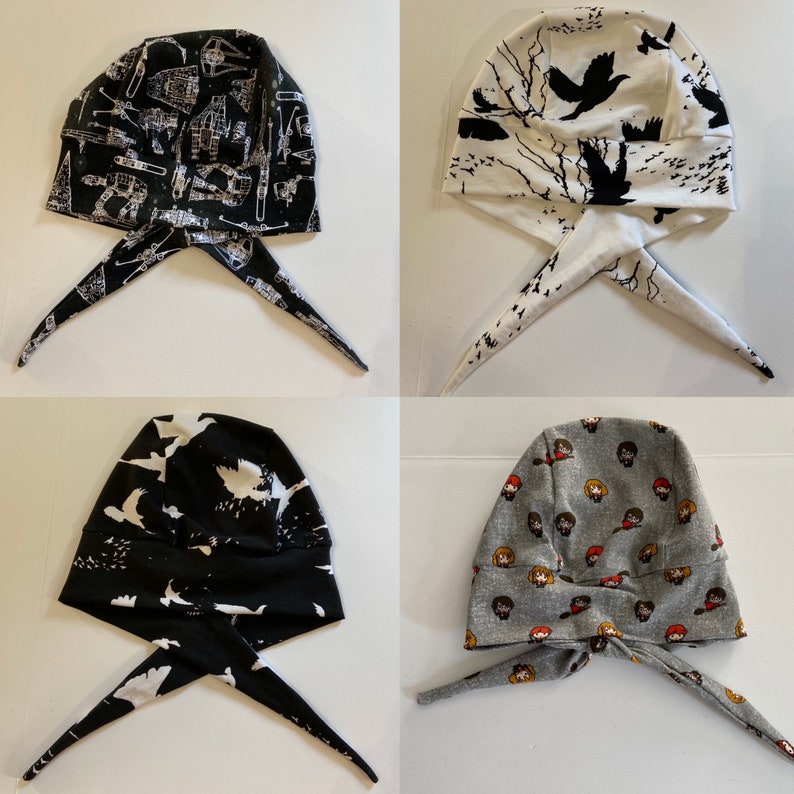 May include: Four different fabric head coverings with ties. The head coverings are black and white with various patterns, including birds, stars, and a graphic print. The head coverings are tied at the back of the neck.