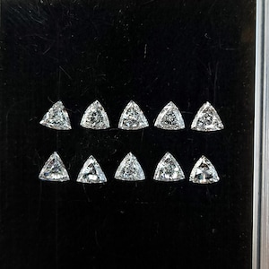 natural diamond trillion side stones in a case close up, calibrated 3x3mm triangle diamonds shown in rows for matched sets, crisp corners and bright reflections, fine jewelry supply F G VVS VS