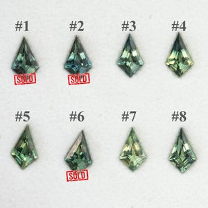May include: Eight kite-shaped faceted gemstones arranged in two rows, numbered #1 through #8. The stones display various shades of green and blue-green. Items #1, #2, and #6 feature a red rectangular stamp with the text SOLD below them.