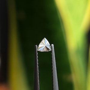 macro tweezers shot of a trillion cut natural diamond, calibrated 3x3mm triangle side stone with crisp points and clean facet junctions, face up sparkle in daylight, F G near colorless VVS VS