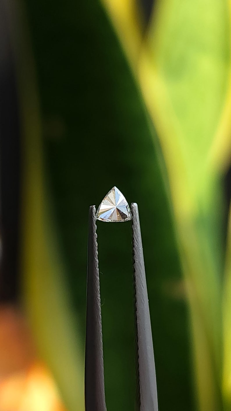 macro tweezers shot of a trillion cut natural diamond, calibrated 3x3mm triangle side stone with crisp points and clean facet junctions, face up sparkle in daylight, F G near colorless VVS VS