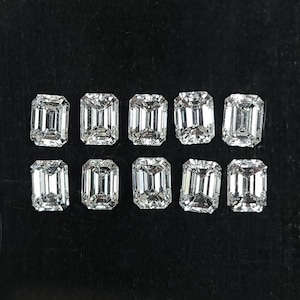 Group of ten natural emerald cut diamonds arranged in two rows on a black background, calibrated 3x2mm and 4x3mm F G SI side stones for rings and fine jewelry.