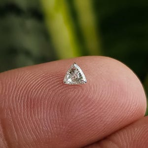 single calibrated 3x3mm trillion cut natural diamond on fingertip, triangle accent stone for halo and three stone settings, clean bright look in natural daylight, F G color VVS VS clarity