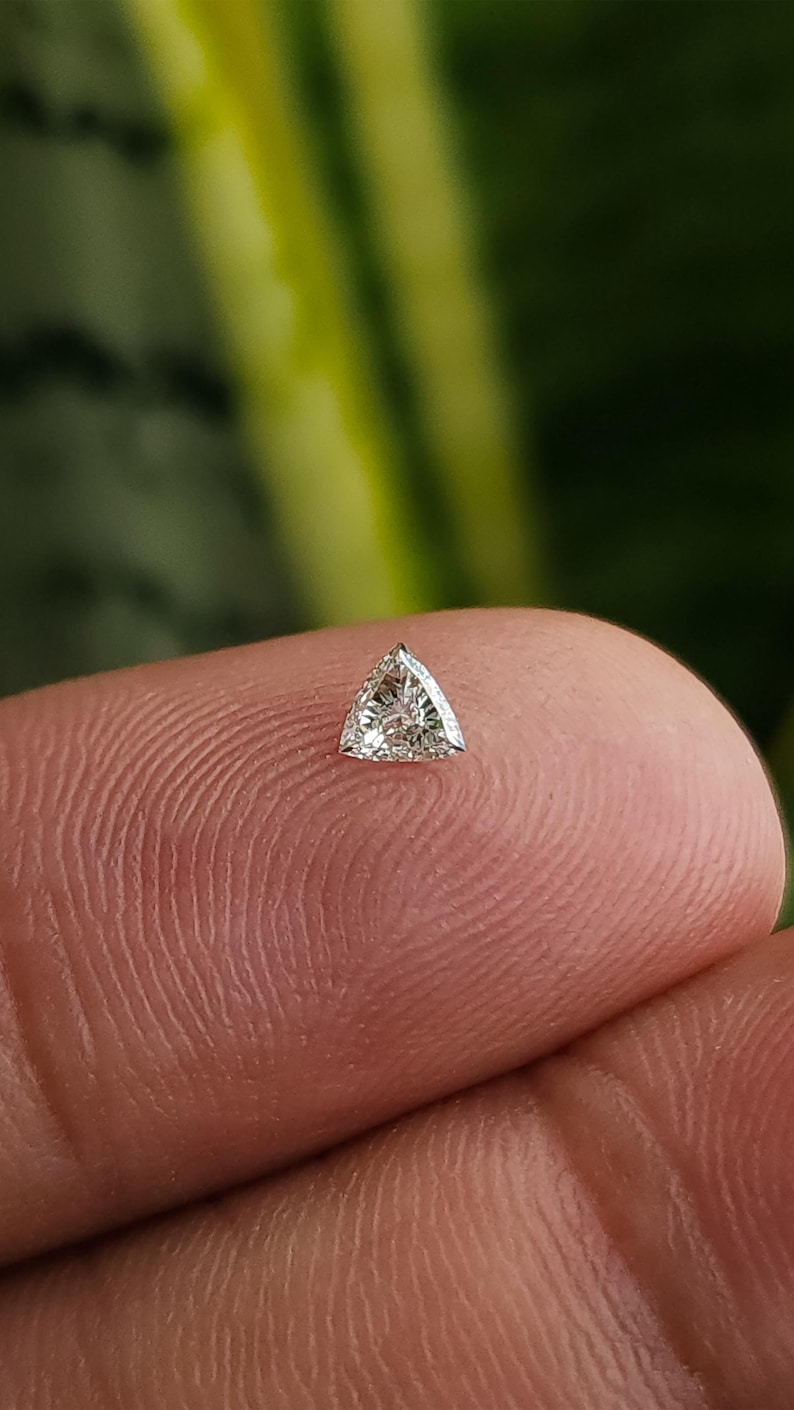 single calibrated 3x3mm trillion cut natural diamond on fingertip, triangle accent stone for halo and three stone settings, clean bright look in natural daylight, F G color VVS VS clarity