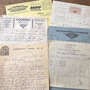 May include: A collection of aged documents, including receipts, letters, and printed ephemera. The papers vary in color from cream to yellow, with handwritten text and printed logos. Some documents feature the text "Gooding County" and "Hagerman Lodge No. 57".