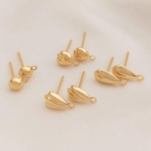 May include: Six gold-toned earring findings, including two round, two teardrop-shaped, and two teardrop-shaped with a textured design.