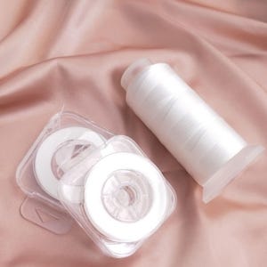 Puede incluir: Una taza de cerámica blanca con un asa negra y el texto "But First, Coffee" en negrita negra. La taza se encuentra sobre un fondo borroso, sugiriendo un ambiente acogedor.