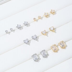 Puede incluir: Un juego de 10 hallazgos para pendientes con detalles de cristal transparente. Los hallazgos tienen forma de estrellas, corazones y rectángulos. Los hallazgos están hechos de metal dorado y plateado.