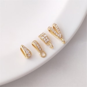 May include: Four gold-tone pendant clasps with clear crystal accents. The clasps are in different shapes and sizes.