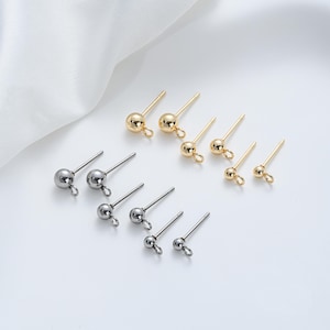 May include: A set of earring findings with a ball head and a post. The findings are available in gold and silver.