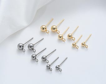 Op de afbeelding: Een set oorknopjes met een bolvormige kop en een pen. De oorknopjes zijn verkrijgbaar in goud en zilver.